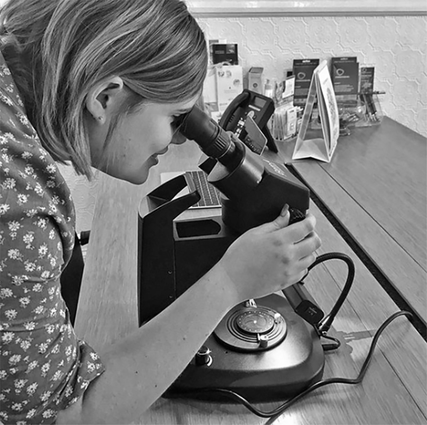 Emily inspects a diamond under our gem microscope in the Serendipity Diamonds showroom.