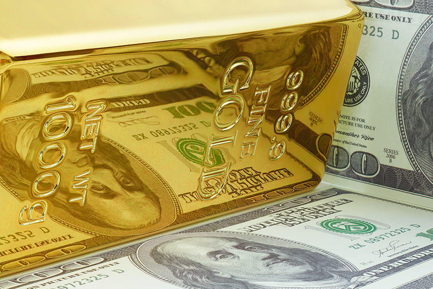 Gold bar shown with dollar bills