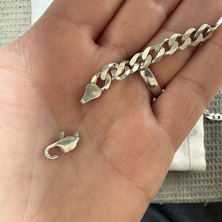 Broken spring on a lobster-claw catch in Silver