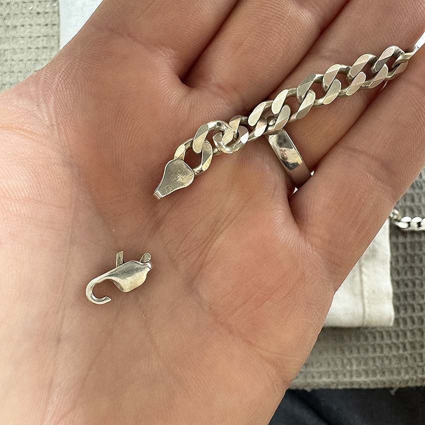 Broken spring on a lobster-claw catch in Silver