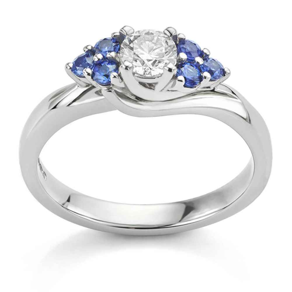 Blue sapphire shoulders in a bespoke diamond ring side view Blue sapphire shoulders in a bespoke diamond ring side view