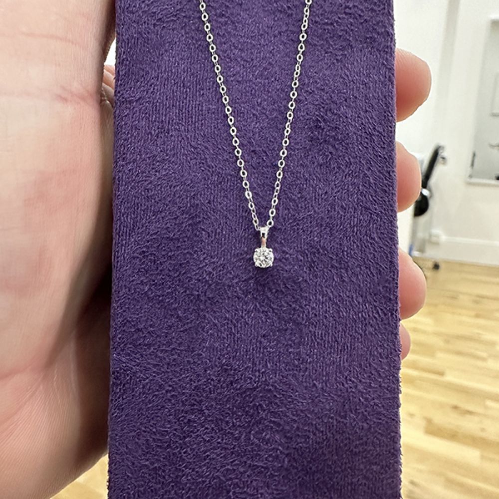 Showroom view of the diamond solitaire necklace on a display pad 0.15 carat diamond solitaire necklace