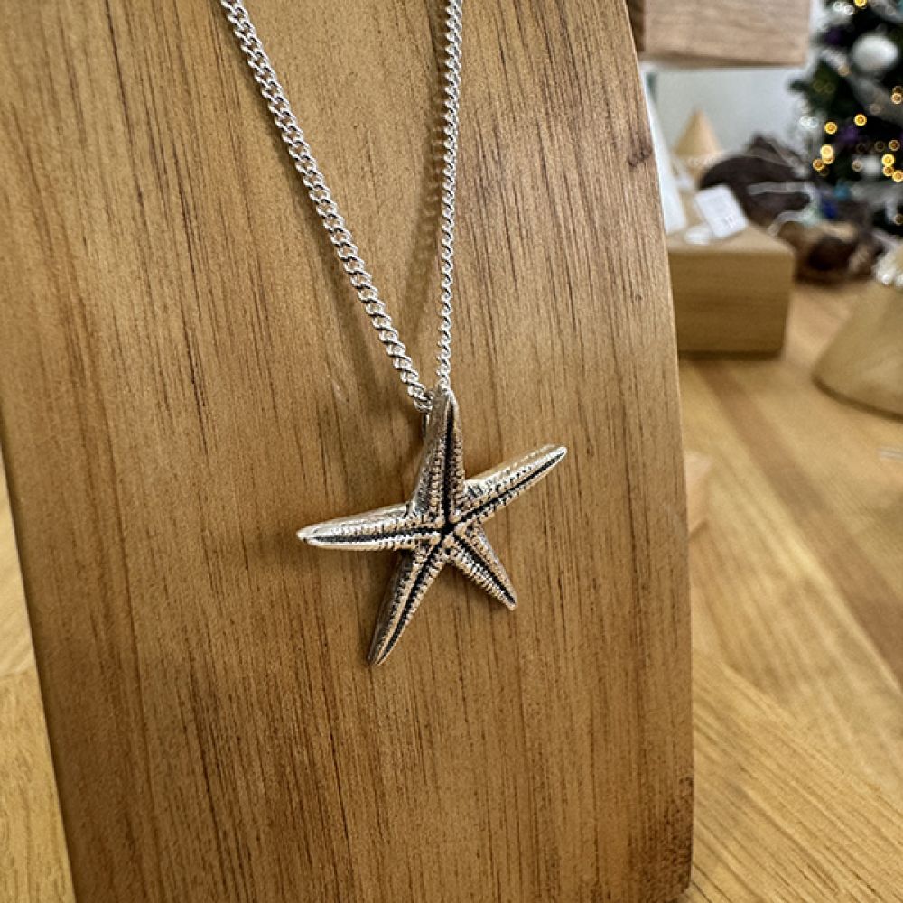 Handmade Silver starfish necklace on stand in the Serendipity showroom in Ryde
