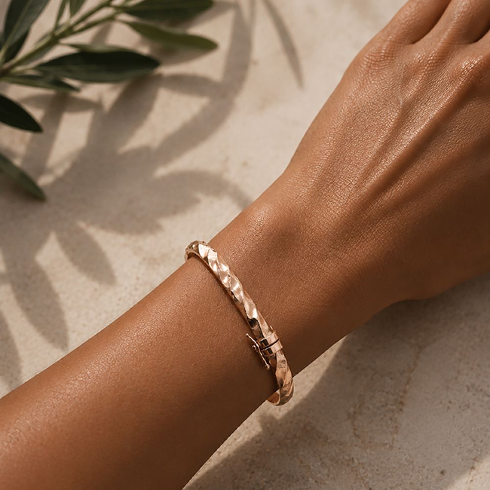 Pre-loved rose gold hinged bangle shown on the wrist