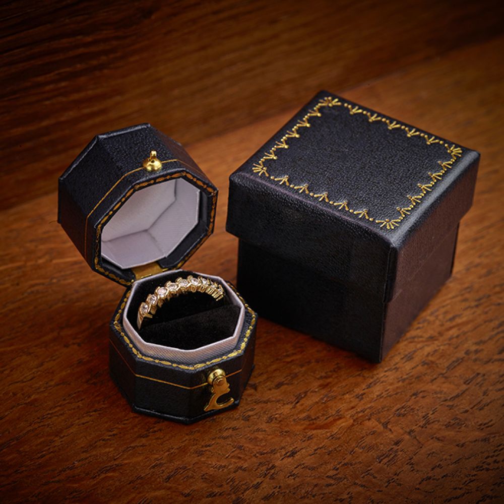 9 stone half eternity ring in yellow gold wood background