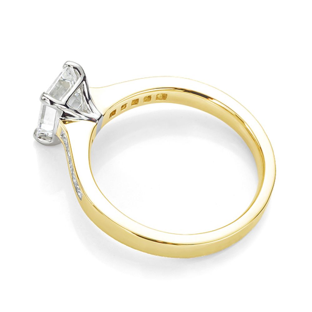 Emerald cut diamond engagement ring with Princess cut diamond shoulders yellow gold side view