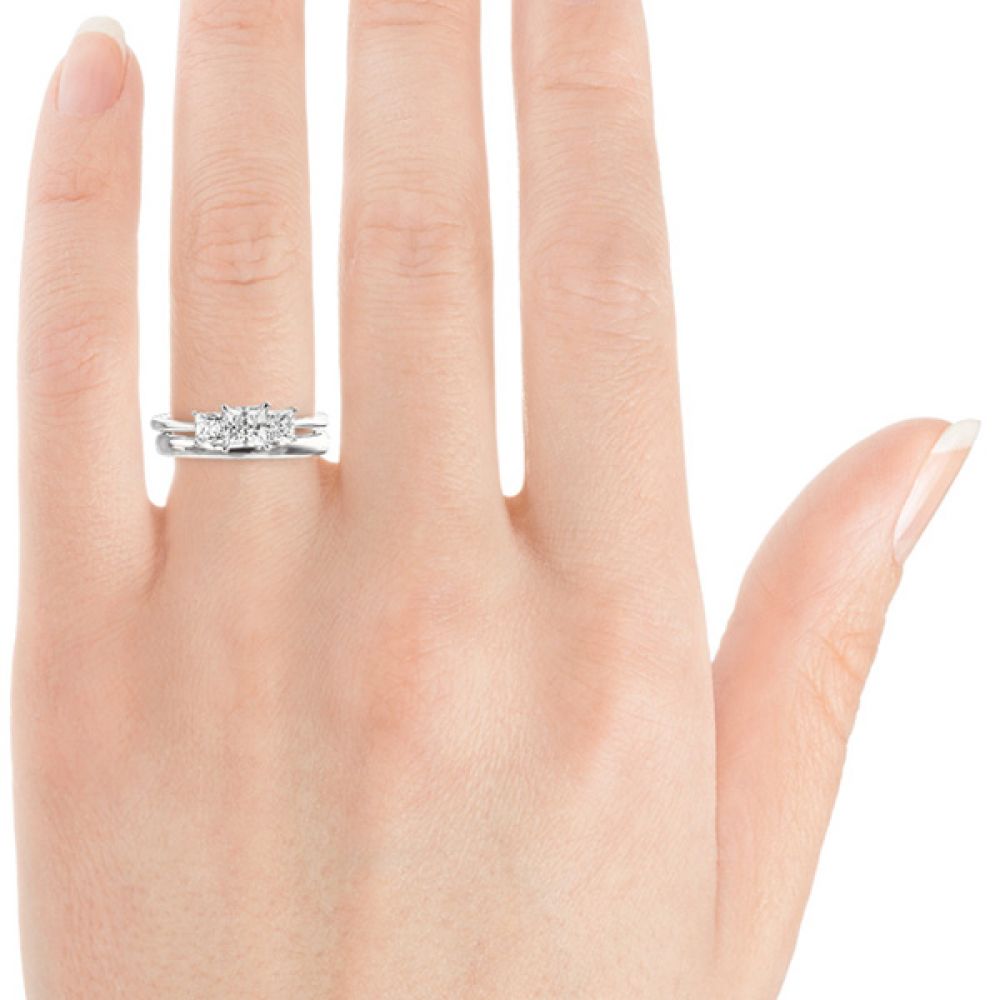 Showing a plain wedding ring sat with the 1 carat version of the Princess cut trilogy ring on the hand