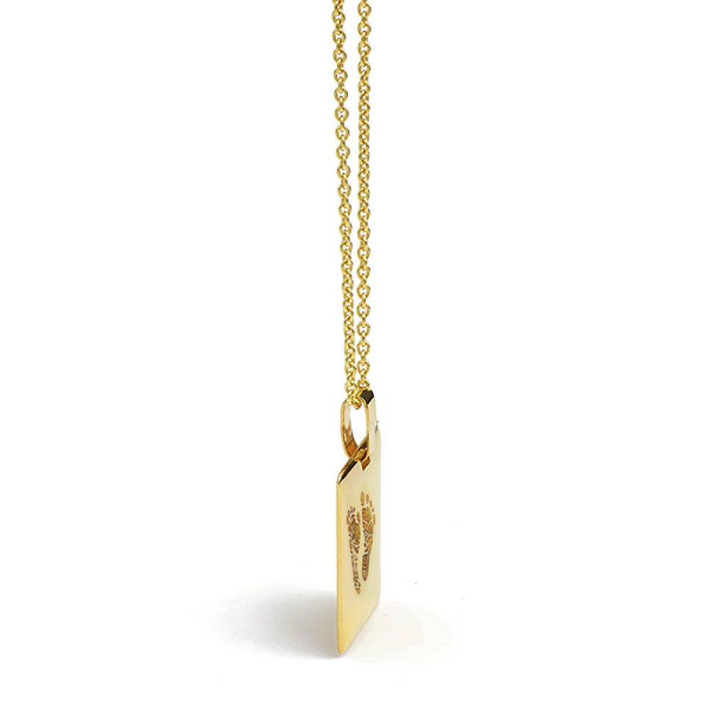Side view of gold footprint engraved pendant Side view of gold footprint engraved pendant